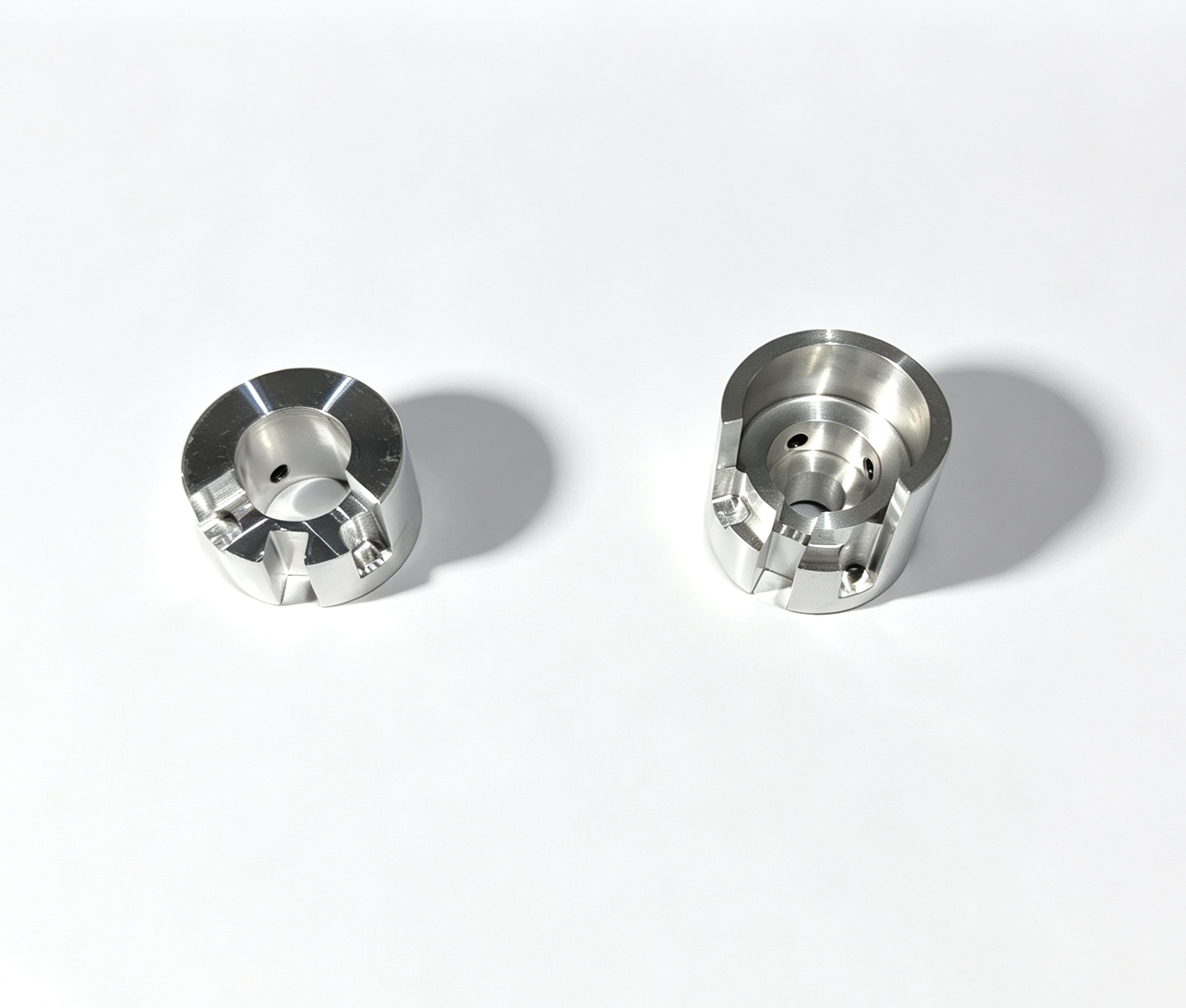 Two machined cylindrical metal components on white background.