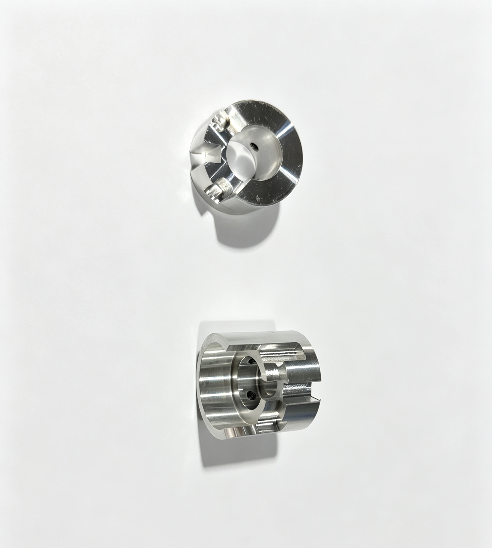 Two machined metallic industrial components on white background.