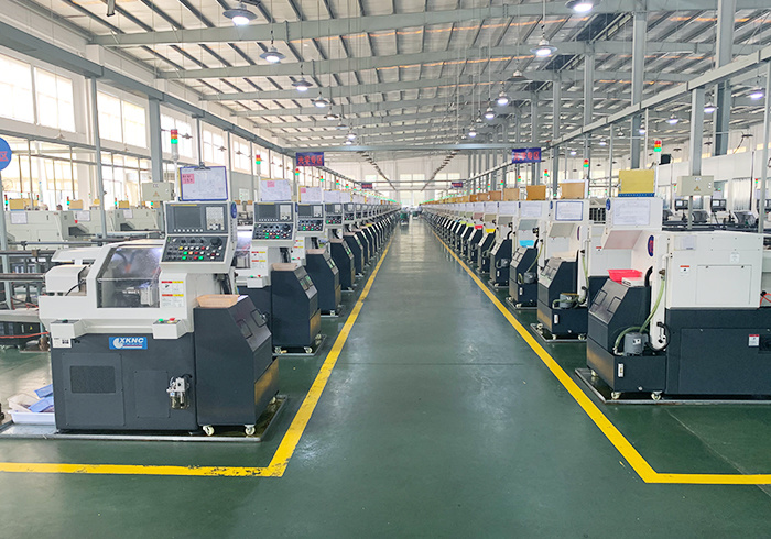 Rows of precision CNC machines line a factory floor.